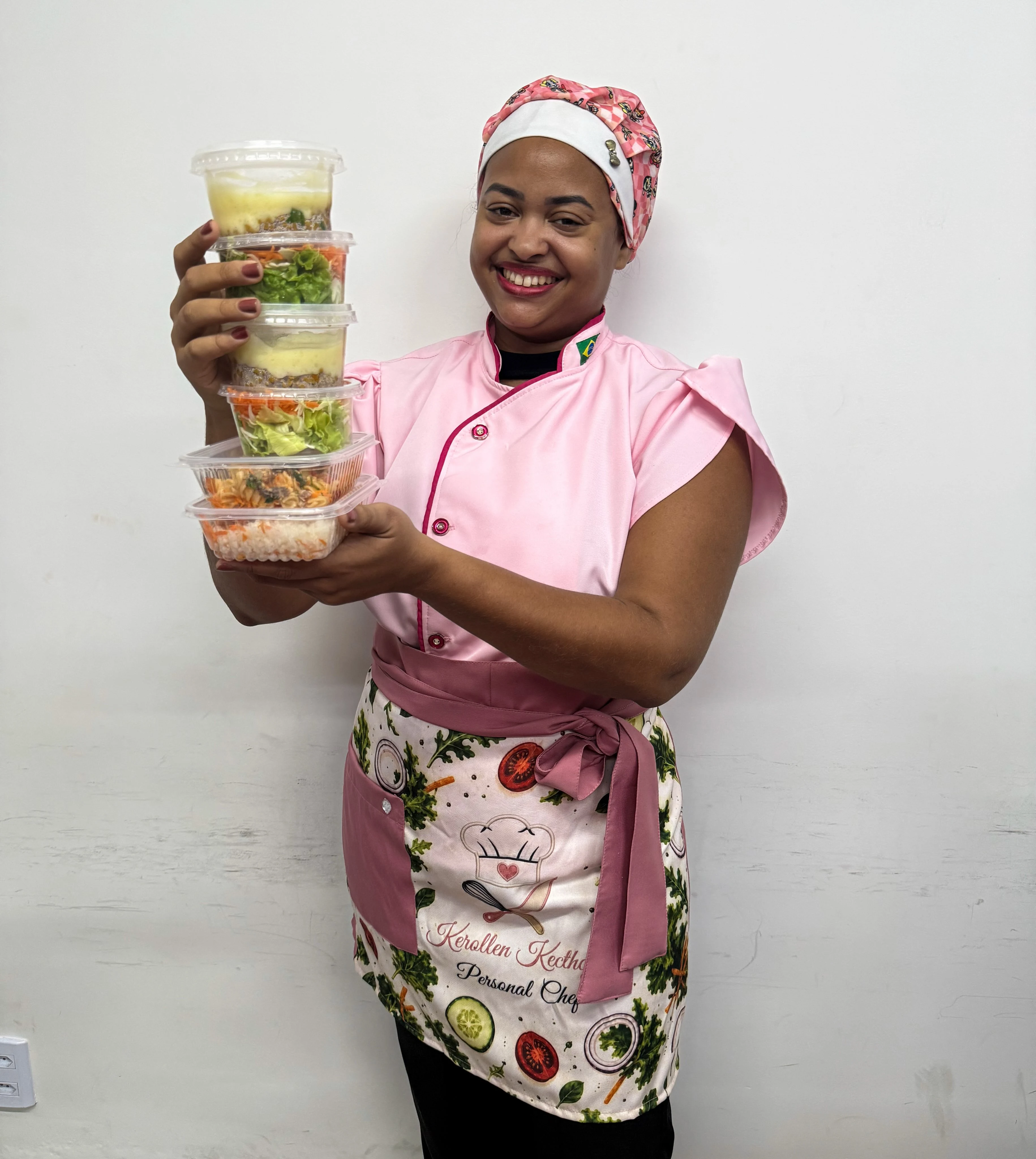 Dra. Kerollen Kecthcya com o uniforme de Personal Chef entregando marmitas